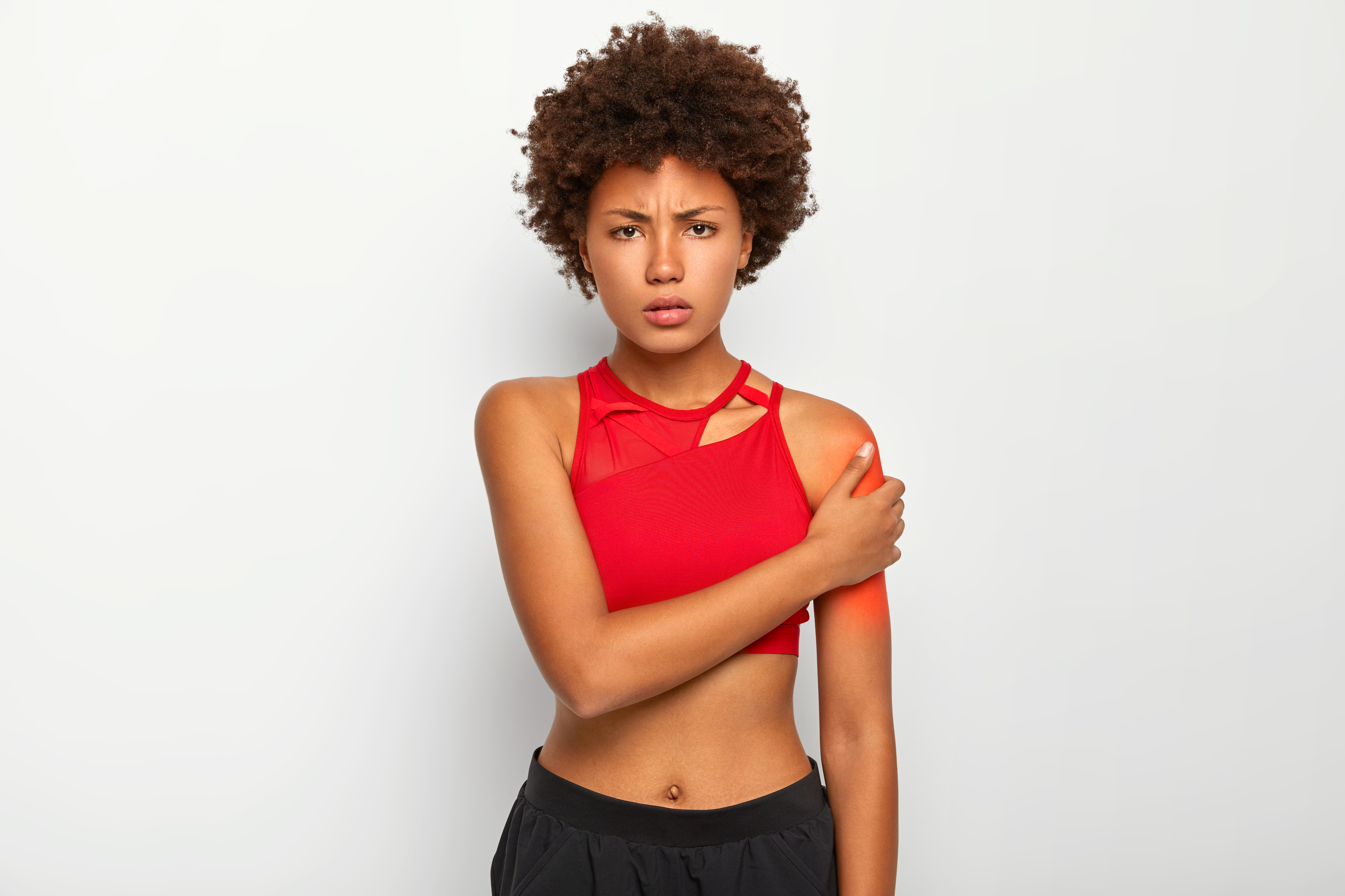 displeased-woman-with-slim-figure-dressed-in-red-top-and-trousers-touches-shoulder-suffers-from-pain-being-injured.jpg